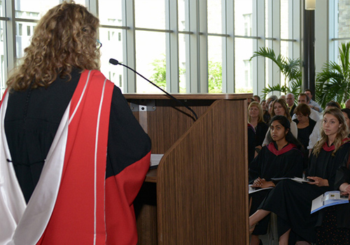 Students at graduation listening to speaker