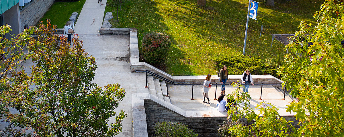 Ariel photo of students talking outside the St. James Building. 